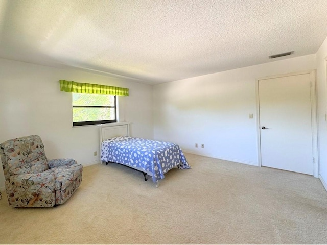 carpeted bedroom featuring visible vents and a textured ceiling