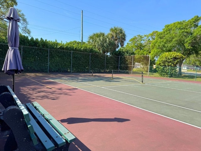 view of tennis court with community basketball court and fence