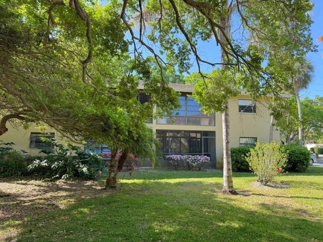 view of front of house featuring stucco siding and a front lawn