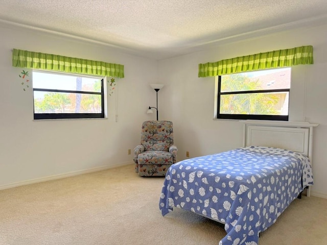 bedroom with baseboards, carpet floors, and a textured ceiling