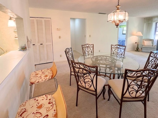 carpeted dining room with an inviting chandelier, baseboards, and visible vents