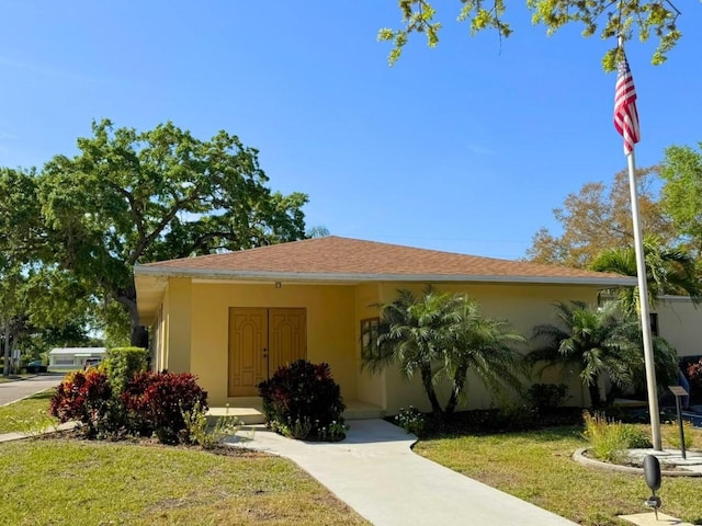 view of front facade featuring stucco siding and a front lawn