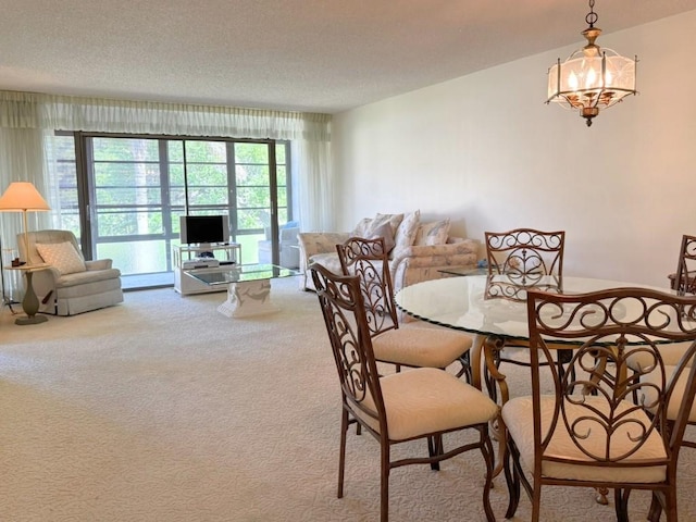 dining space featuring a chandelier, a textured ceiling, and carpet floors