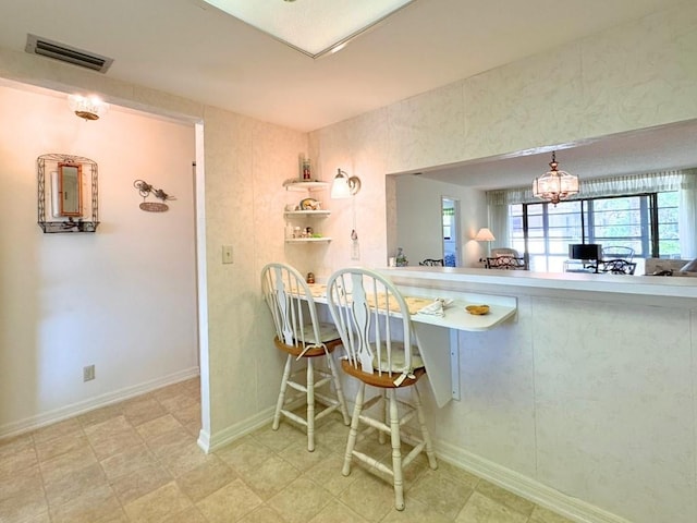 kitchen with a notable chandelier, baseboards, and visible vents