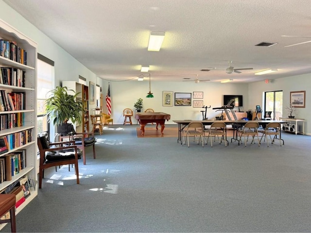 interior space with visible vents, carpet floors, a textured ceiling, and a ceiling fan