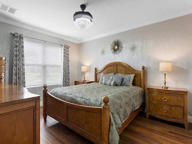 bedroom with an inviting chandelier, crown molding, and dark hardwood / wood-style floors