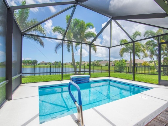 view of swimming pool featuring a water view, a patio, a yard, and glass enclosure