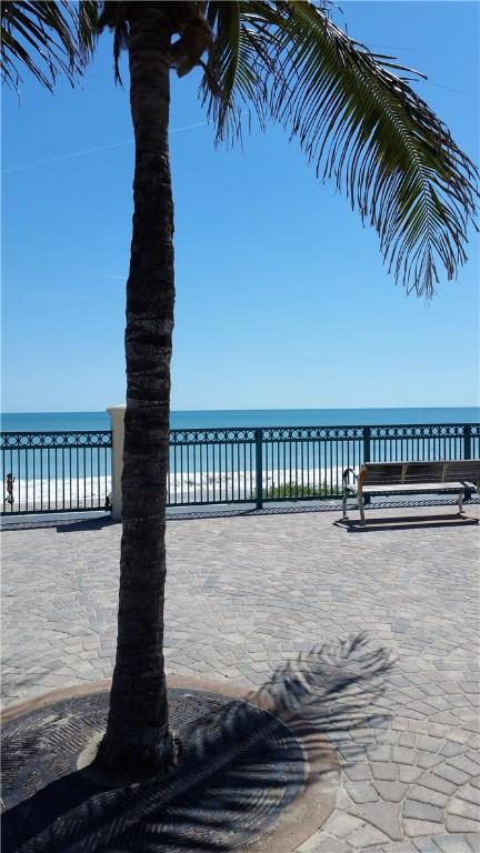 view of patio / terrace featuring a water view and a beach view