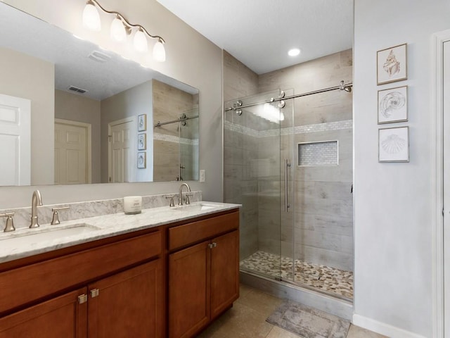 bathroom with vanity, tile patterned flooring, and a shower with door