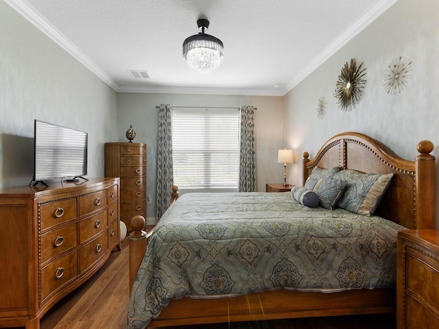 bedroom with crown molding, wood-type flooring, and an inviting chandelier