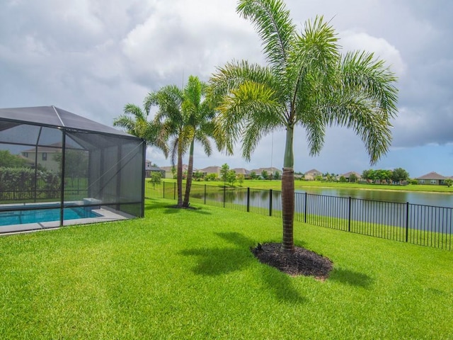 view of yard with a fenced in pool, glass enclosure, and a water view