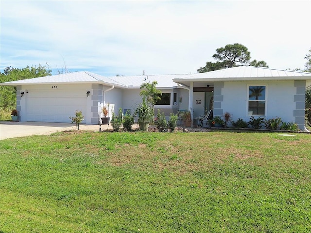 ranch-style house with stucco siding, a front yard, metal roof, a garage, and driveway