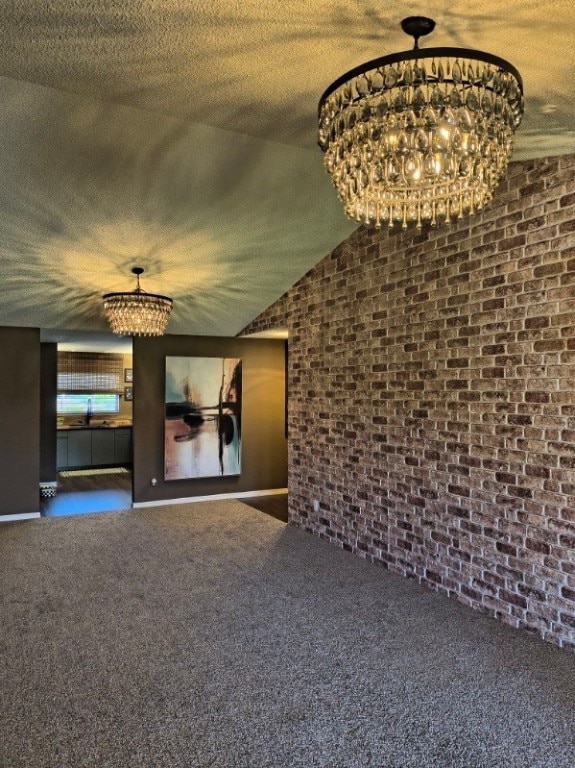 217 Grove Isle Cir Unit 217, Vero Beach, FL 32962 - empty room featuring carpet flooring, brick wall, and a notable chandelier