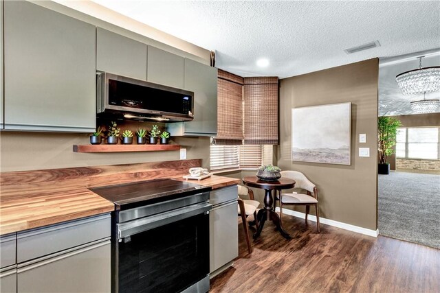 217 Grove Isle Cir Unit 217, Vero Beach, FL 32962 - kitchen with appliances with stainless steel finishes, visible vents, a textured ceiling, wood counters, and gray cabinetry