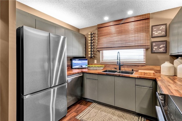 217 Grove Isle Cir Unit 217, Vero Beach, FL 32962 - kitchen featuring appliances with stainless steel finishes, a sink, a textured ceiling, wooden counters, and gray cabinetry