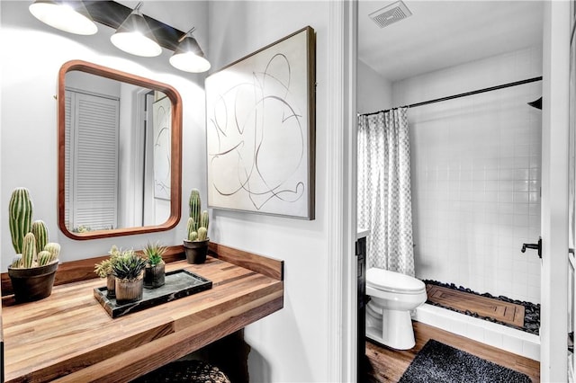 217 Grove Isle Cir Unit 217, Vero Beach, FL 32962 - full bathroom with visible vents, wood finished floors, toilet, and tiled shower
