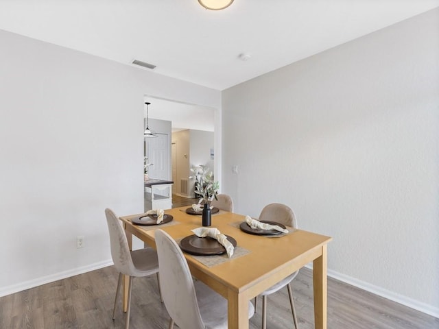 dining space with wood-type flooring