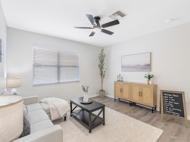 living room with light hardwood / wood-style floors and ceiling fan