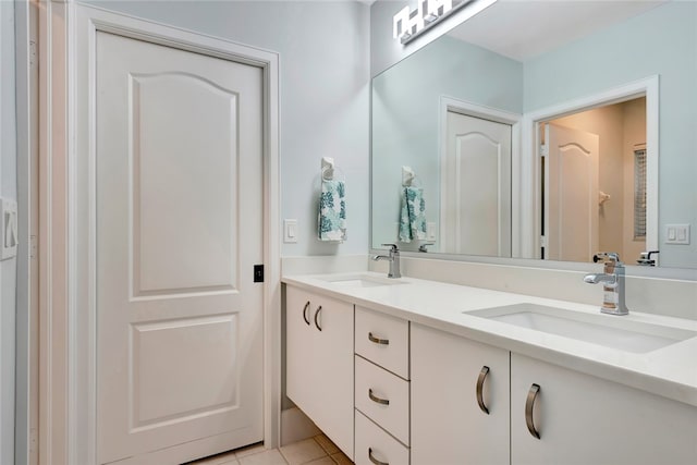 full bath with double vanity, tile patterned flooring, and a sink