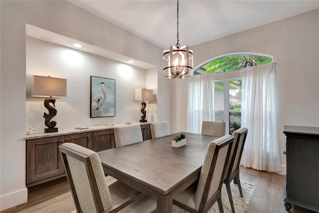 dining space with recessed lighting, light wood-style flooring, baseboards, and an inviting chandelier