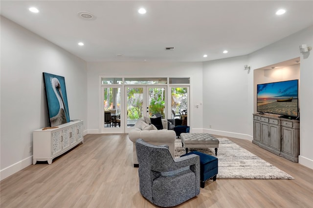 living area featuring recessed lighting, light wood-style flooring, baseboards, and french doors