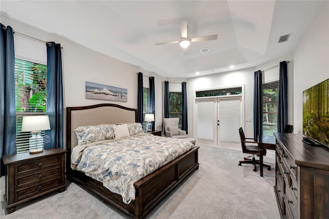 bedroom featuring light carpet, a ceiling fan, visible vents, access to exterior, and a raised ceiling