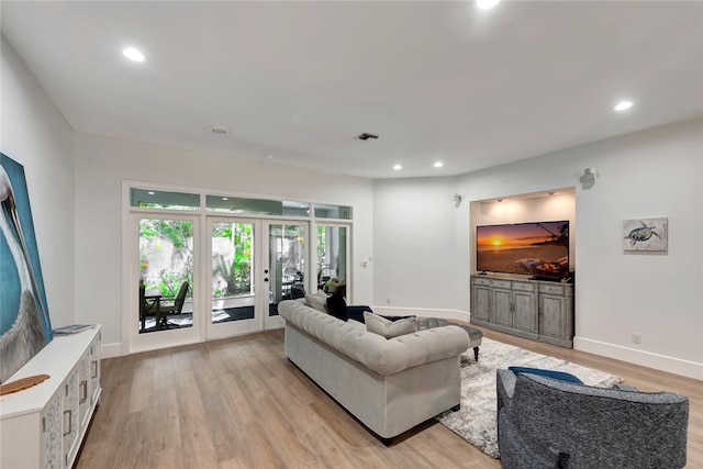 living area featuring baseboards, recessed lighting, and light wood-style floors