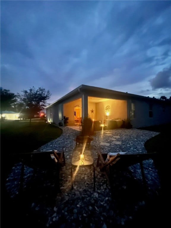 property exterior at dusk featuring a patio area