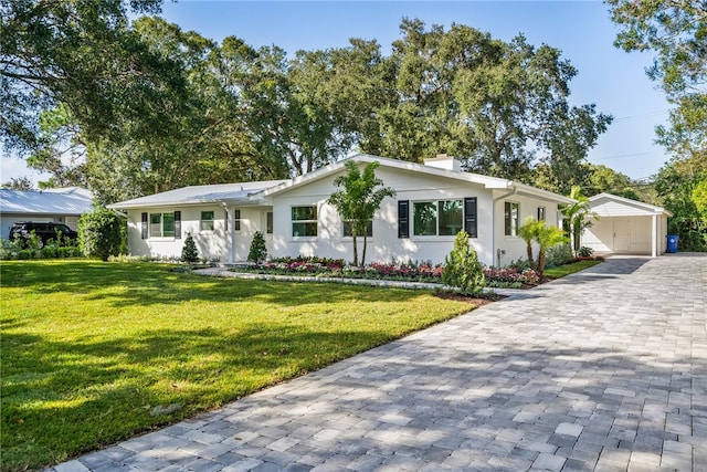 ranch-style home with a garage, an outdoor structure, and a front lawn