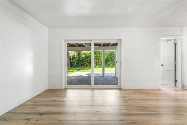 spare room with wooden walls and light hardwood / wood-style floors