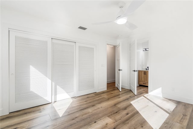 unfurnished bedroom with ceiling fan, a closet, and light wood-type flooring