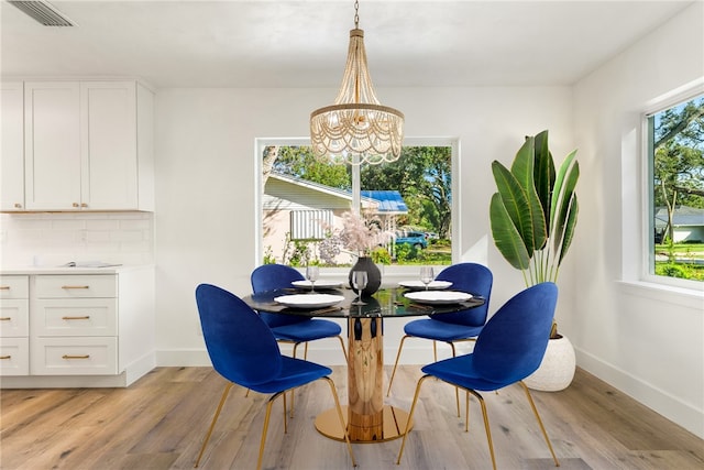 dining area with a notable chandelier and light hardwood / wood-style floors