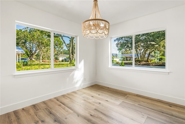 unfurnished room featuring light hardwood / wood-style floors and plenty of natural light