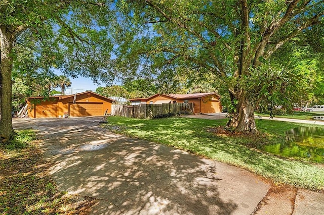 single story home featuring fence, concrete driveway, and a front yard