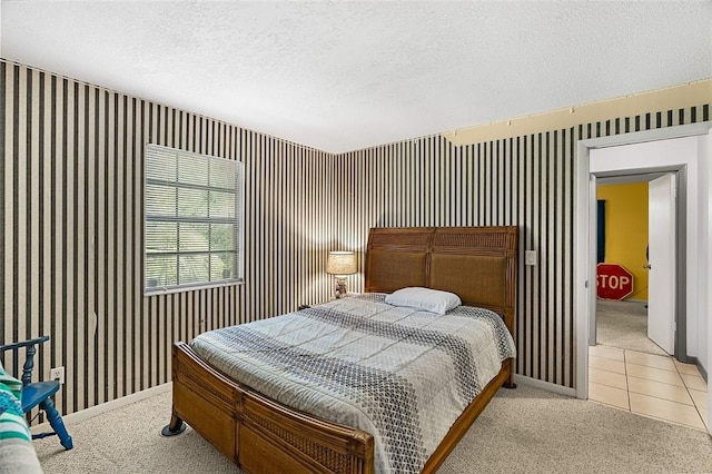 bedroom with a textured ceiling, light tile patterned floors, light colored carpet, baseboards, and wallpapered walls