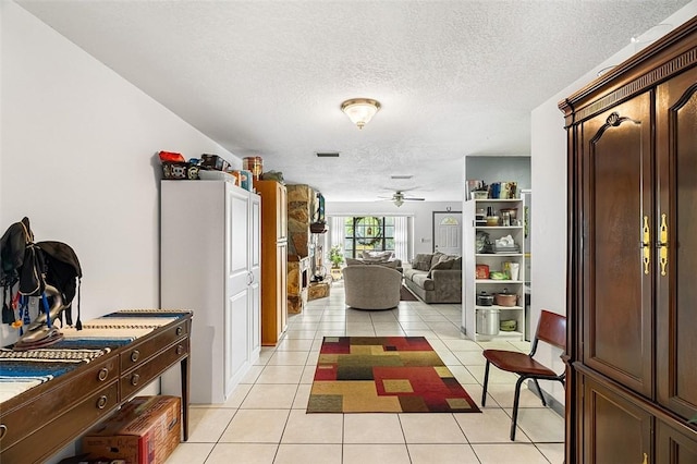 hallway featuring a textured ceiling and light tile patterned floors