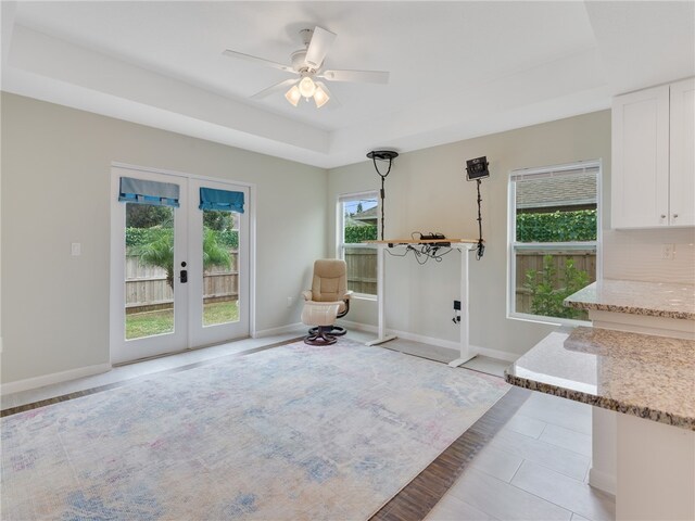 entryway featuring french doors, a raised ceiling, ceiling fan, and light tile patterned flooring