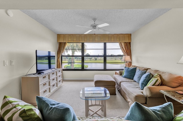 living room with ceiling fan, a textured ceiling, and light carpet