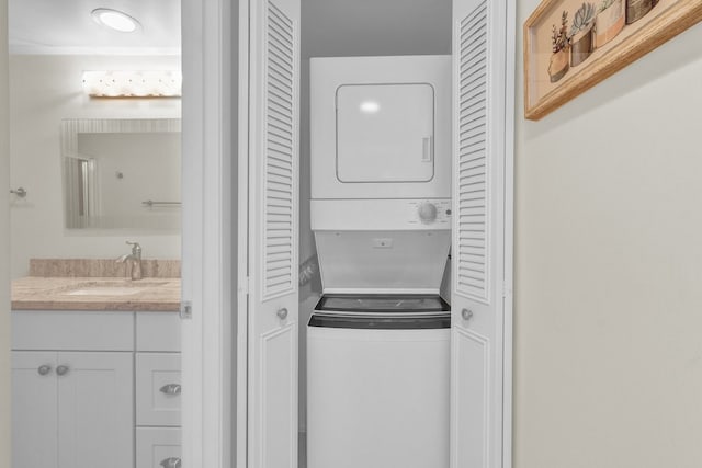 clothes washing area with stacked washing maching and dryer and sink