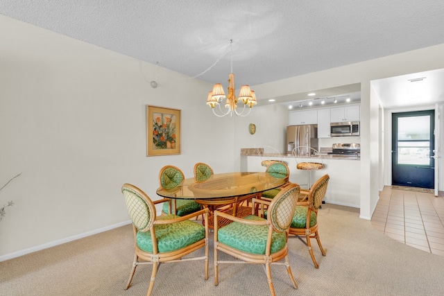 carpeted dining area with a textured ceiling and a chandelier