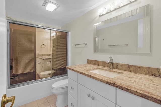 full bathroom featuring toilet, vanity, tile patterned floors, and enclosed tub / shower combo