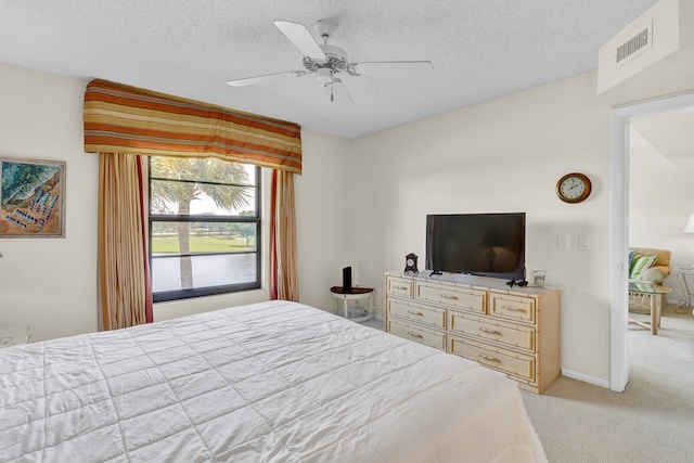 carpeted bedroom with ceiling fan and a textured ceiling