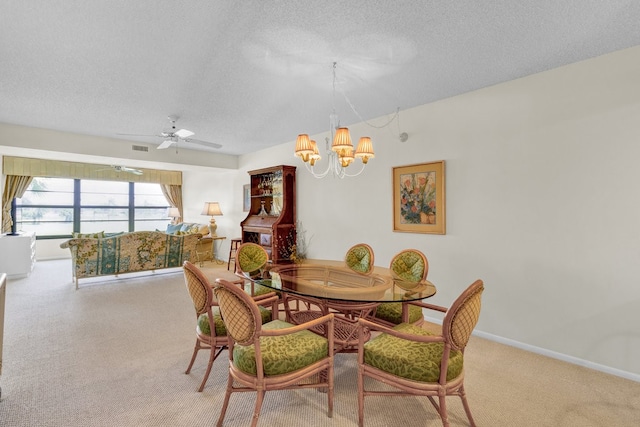 dining space with ceiling fan with notable chandelier, light colored carpet, and a textured ceiling