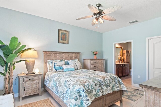10095 W Villa Cir, Vero Beach, FL 32966 - bedroom featuring visible vents, light tile patterned flooring, baseboards, a ceiling fan, and ensuite bath