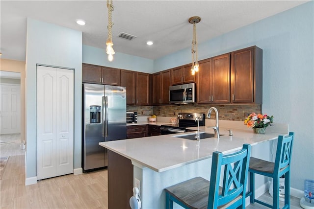 10095 W Villa Cir, Vero Beach, FL 32966 - kitchen with visible vents, decorative backsplash, a peninsula, a sink, and stainless steel appliances