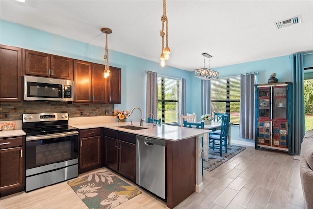 10095 W Villa Cir, Vero Beach, FL 32966 - kitchen with a sink, appliances with stainless steel finishes, dark brown cabinets, and light countertops