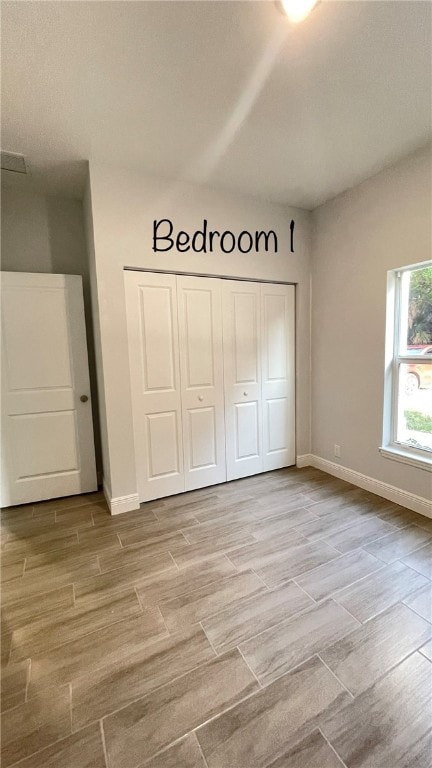 unfurnished bedroom with a closet and light hardwood / wood-style floors