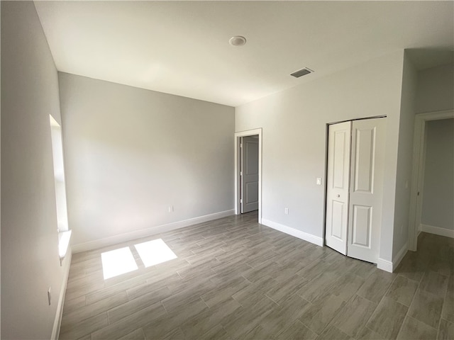 unfurnished bedroom featuring hardwood / wood-style floors and a closet