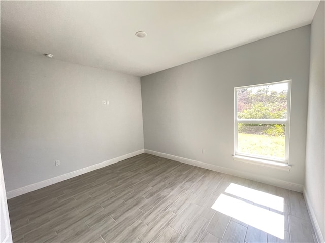 unfurnished room with hardwood / wood-style flooring