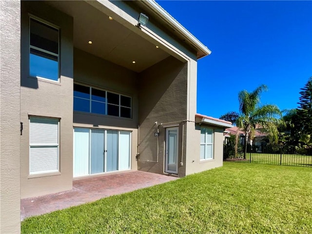 back of house featuring a patio area and a lawn